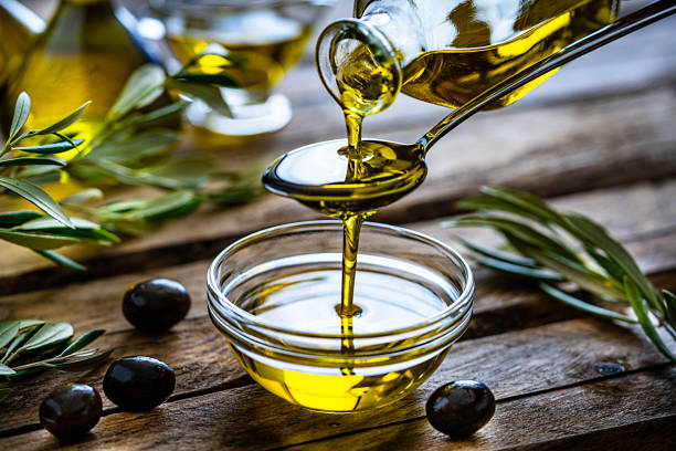 سكب زيت الزيتون البكر الطبيعي مع ثمار الزيتون